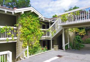 Casa con terraza blanca y escalera en Carriage House Inn, en Carmel