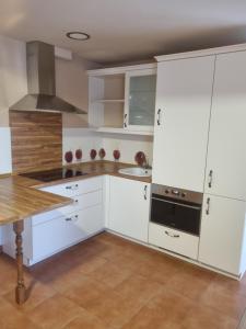 a kitchen with white cabinets and a sink at Apartamentos Villa Sofía in San Vicente de la Barquera