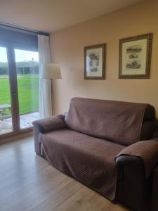 a living room with a couch and a sliding glass door at Apartamentos Villa Sofía in San Vicente de la Barquera