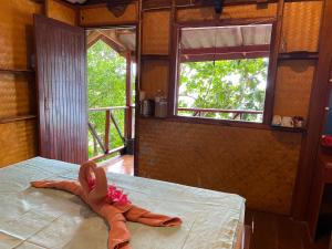 a doll laying on a bed in a room with a window at KoyAo Bungalows in Trang +5 photos