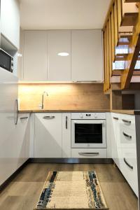a kitchen with white cabinets and a sink at Chalupa Evka in Terchová +18 photos