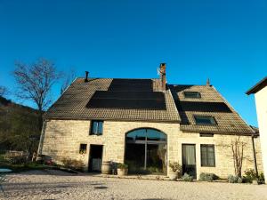 a house with solar panels on the roof at La Maison de Beaume in Créancey