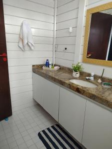 un baño con lavabo y espejo en Casa charmosa a beira mar, en Paulista 36 fotos más