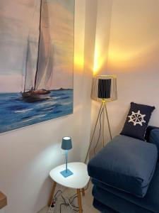 a living room with a blue couch and a sail boat at Holiday House Baska Hill in Jurandvor