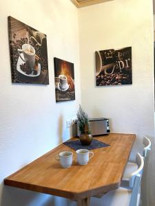 a wooden table with two cups on top of it at Traumhaftes Tiny Apartment in Weingarten