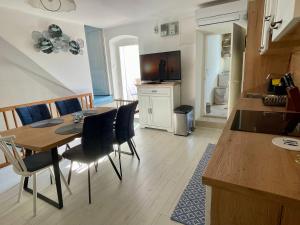 una cucina e una sala da pranzo con tavolo e sedie di Holiday House Baska Hill a Jurandvor