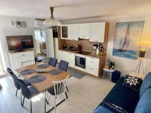 a kitchen and living room with a table and chairs at Holiday House Baska Hill in Jurandvor