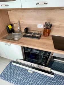 a kitchen with a sink and a microwave at Holiday House Baska Hill in Jurandvor