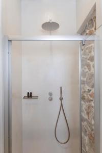 a bathroom with a shower with a glass door at Aurora House Astypalea B in Pera Gyalos