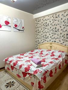 Un dormitorio con una cama con flores rojas. en Квартира в центре, VEFA, en Bishkek