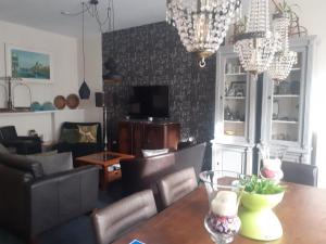a living room with a dining room table and chandeliers at The Dutch Hills in Gulpen