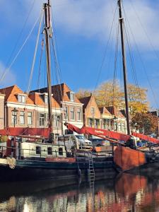 una barca ormeggiata in acqua davanti alle case di Klipper Engelburg a Zwolle