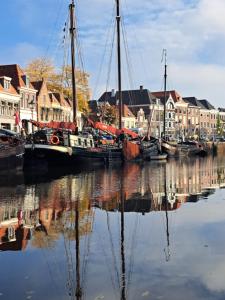 a group of boats docked in a harbor with houses at Klipper Engelburg in Zwolle