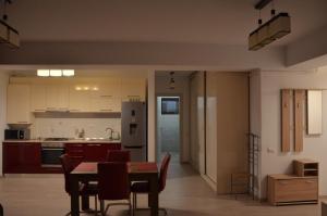 a kitchen and dining room with a table and chairs at Bujorului Residence - 2Br Apartament Central in Craiova