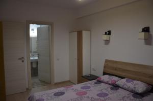 a bedroom with a bed and a bathroom at Bujorului Residence - 2Br Apartament Central in Craiova
