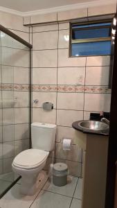 a bathroom with a toilet and a sink at Lindo Apto Itapema Meia Praia Frente ao Mar, 6 pessoas, alto padrão in Itapema +11 photos