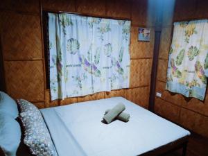a bed with a toy on it in a room at White Hat EL NIDO in El Nido