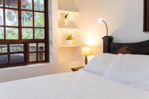 a bedroom with a white bed and a window at Hotel Chalet El Castillo by Majuva in Armenia