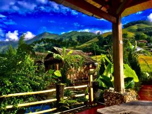 a view from the porch of a house with mountains in the background at Eco Rice Fields House in Sa Pa