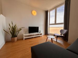 salon z kanapą, telewizorem i oknem w obiekcie Cozy apartments and deluxe lofts in Fuerteventura w mieście Cotillo