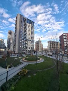 a park in a city with tall buildings at Belgrade Waterfront Lux Studio Apartment in Belgrade