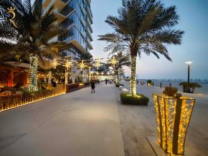 a street with palm trees and lights on the beach at Azure Bliss 1BR Retreat - Cozy Stay Near Saadiyat Beach & Louvre Abu Dhabi in Abu Dhabi