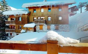 un edificio cubierto de nieve con un montón de nieve en Chalet La Grande Ourse Meribel - 165m2 apartment almost ski-in ski-out, en Méribel