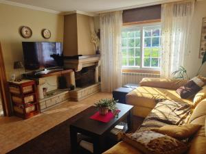 a living room with a couch and a fireplace at Casa familiar cerca de playa América in Nigrán