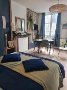 a bedroom with a blue bed and a dining room at Studio 4 personnes aux pieds du château de Blois avec expérience de dormir sous les aurores boréales in Blois