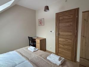 a bedroom with a bed and a wooden door at Janowa Góra 9A in Sienna