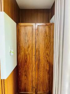 un armario de madera en la esquina de una habitación en Cherry homestay bmt, en Buôn Ðũng