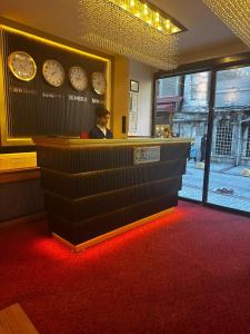 een man die aan een toonbank in een restaurant zit met klokken bij Blueway Hotel Istanbul Bakırköy City Center in Istanbul