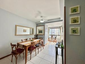 a dining room and kitchen with a table and chairs at Apartamento com vista para o mar in Capão da Canoa