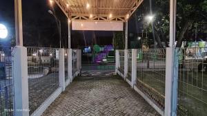 a gate to a petting zoo at night at New Jasmine Guest House by Yurooms in Karangtengah