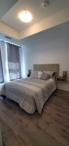 a bedroom with a bed and a large window at 1 Bedroom condo with balcony Erb St Waterloo in Waterloo