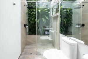a bathroom with a toilet and a shower with plants at Hotel Chalet El Castillo by Majuva in Armenia