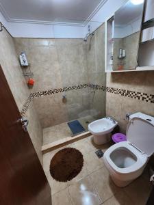 ein Badezimmer mit Toilette und Dusche in der Unterkunft Lago los Molinos Punto Claro villa Silvestre depto 2 dorm y cochera in Villa Ciudad Parque