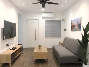 a living room with a couch and a flat screen tv at H62 Muar Home in Muar