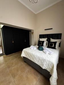 una camera da letto con un letto grande con testiera nera di Dior-X Manor a Durban