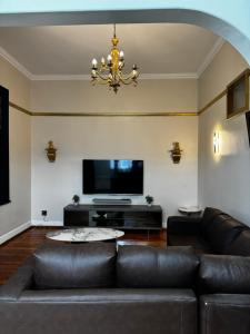 un soggiorno con divano e TV a schermo piatto di Dior-X Manor a Durban