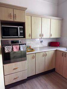 una cucina con armadi in legno e forno a microonde di Dior-X Manor a Durban