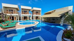 a swimming pool in front of a villa at Villa Dubai Pousada, Restaurante e Pizzaria in Luis Correia