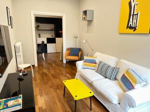 sala de estar con sofá blanco y mesa amarilla en Botticelli 2 Guesthouse, en Roma