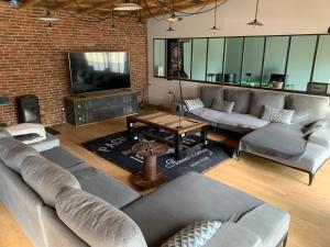 a living room with couches and a flat screen tv at La Dolce vita in Sermersheim