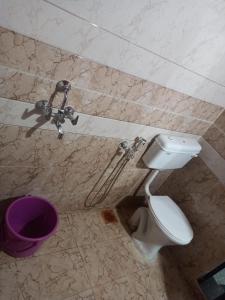 a bathroom with a toilet and a purple bowl at Swastik Holiday Home in Arambol