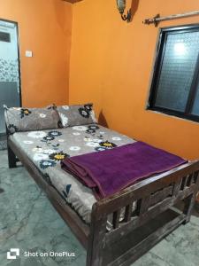 a wooden bed in a room with a window at Swastik Holiday Home in Arambol