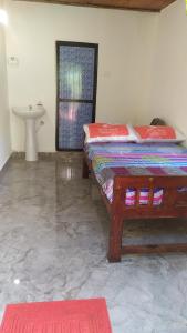 a bedroom with a bed and a sink in a room at Swastik Holiday Home in Arambol