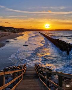 un muelle se extiende hacia el océano al atardecer en seagarden wissant, en Wissant