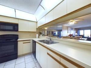 a kitchen with a sink and a stove at Sandcastles 2br2ba Cocoa Beach Ocean Views! in Cocoa Beach