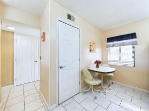a room with a table and a white door at Sandcastles 2br2ba Cocoa Beach Ocean Views! in Cocoa Beach